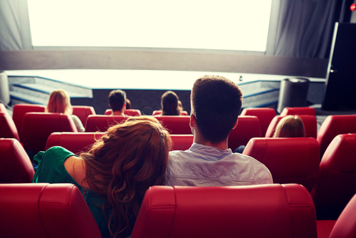 映画館で映画を見るカップル